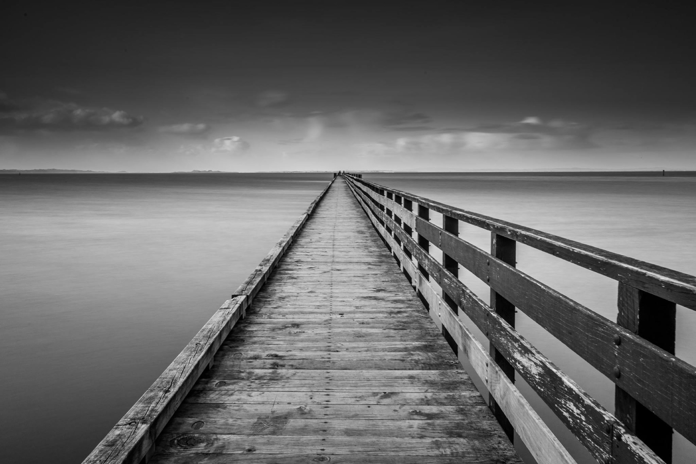 A long wooden wharf extending into still water
